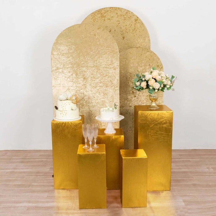 Elegant gold cake display with floral arrangement on gold pedestals.