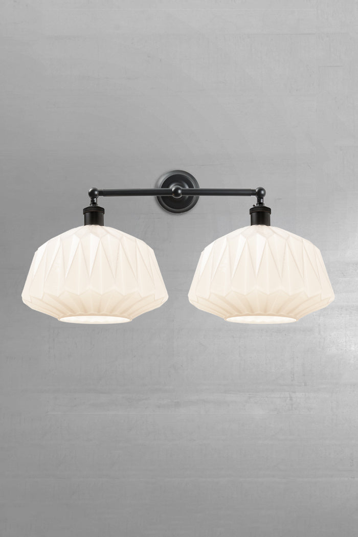 Two opal glass shades with geometric design on a black double swivel wall sconce