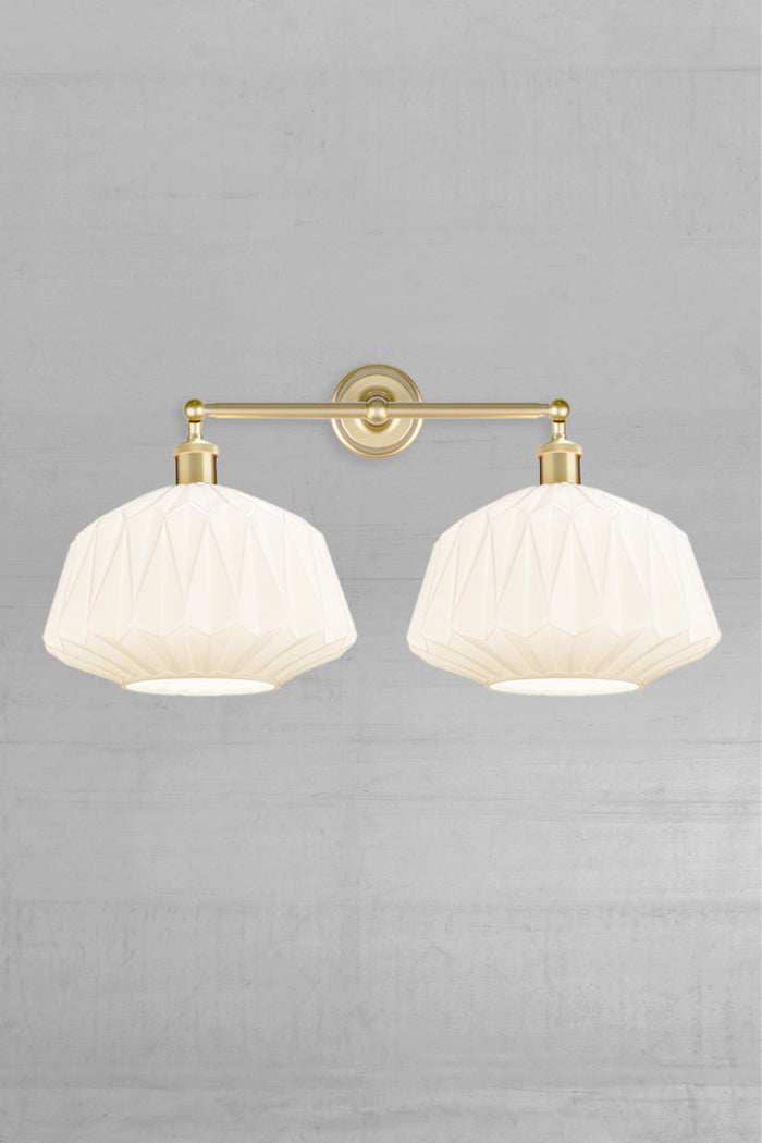 Two opal glass shades with geometric design on a gold/brass double swivel wall sconce