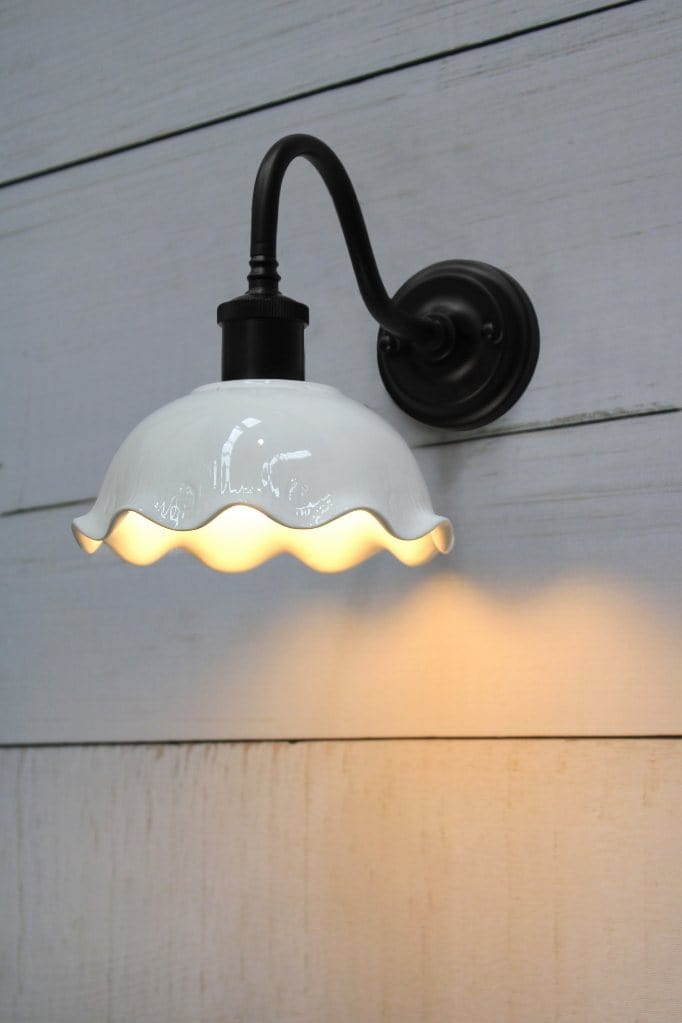 Wall lamp with black gooseneck arm affixed on wall.