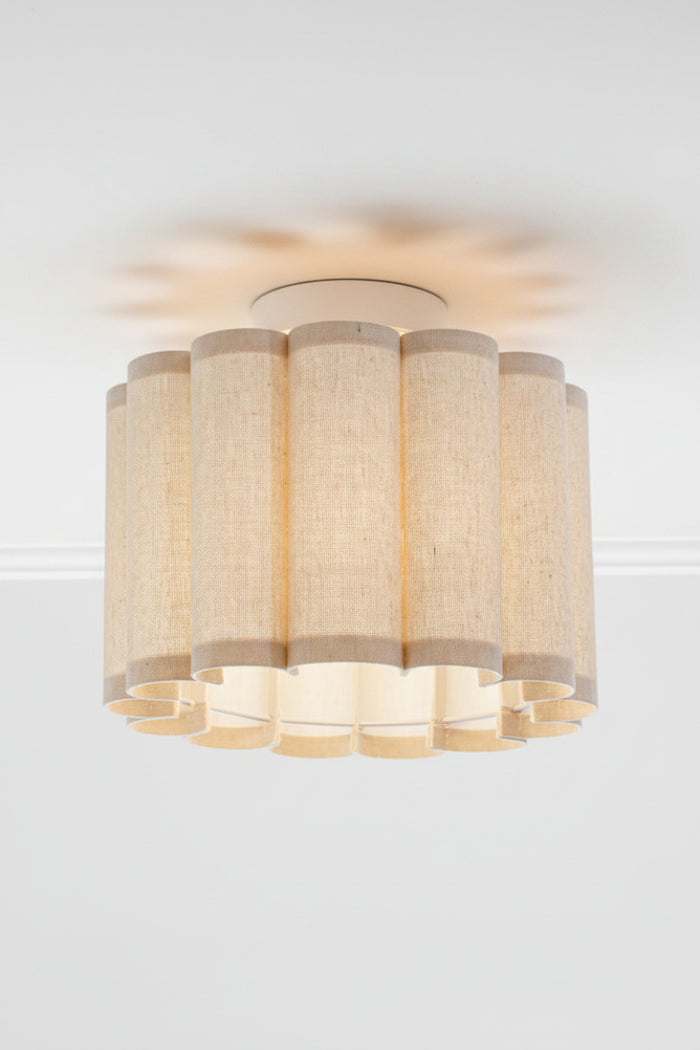 Ceiling ligh with a scalloped fabric shade on a white batten holder.