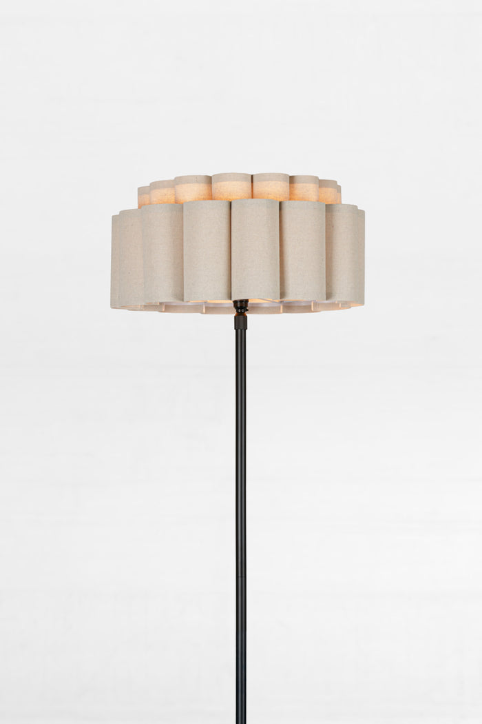 Floor lamp with a beige shade on a white background