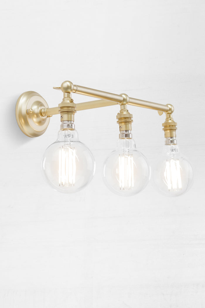 Gold/Brass three lampholder straight arm wall sconce, view angled up.