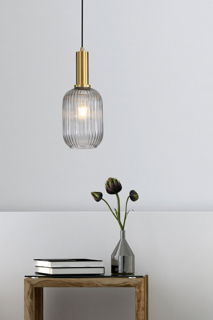 Smoke reeded glass shade with antique brass metalware as a bedside table light.