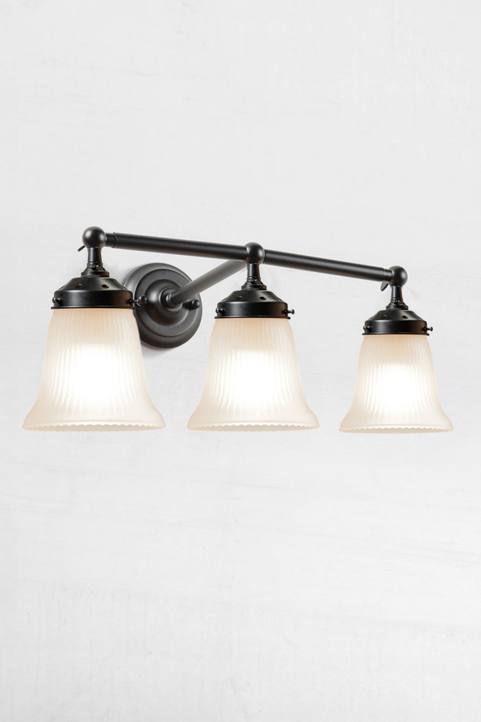 Triple black wall sonce with opal reeded glass shades.