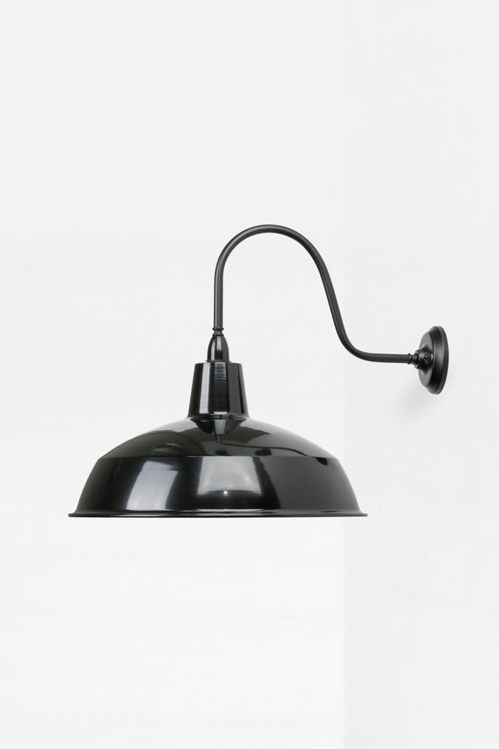 Side view of the outdoor wall light in black with a glossy shade and matt black arm.