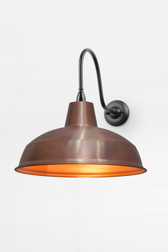 Large warehouse shade in aged copper on an extra large outdoor gooseneck wall sconce.