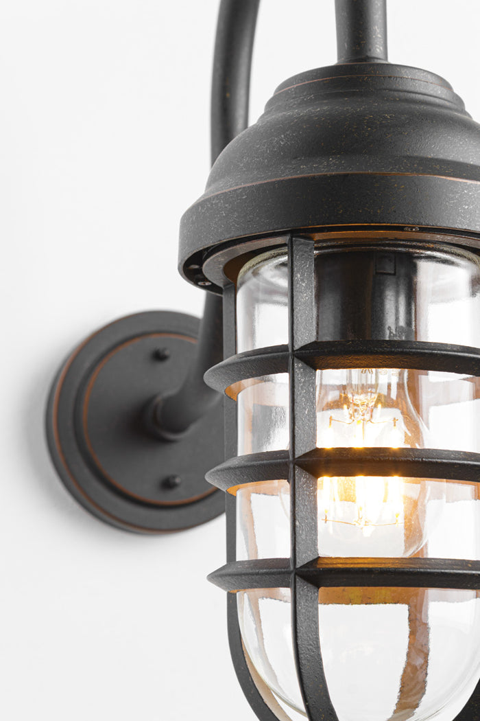 Close up of the wall light without shade, with cage and glass guard.
