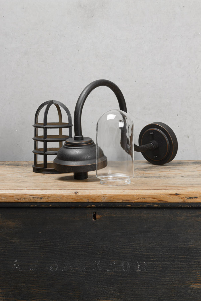 Deconstructed wharf wall light without shade, showing gooseneck arm, cageand glass guard.