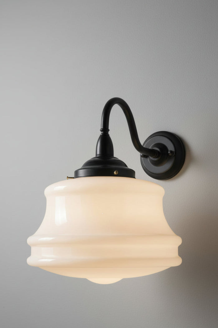 Large opal glass schoolhouse style shade on a black steel gooseneck wall sconce.